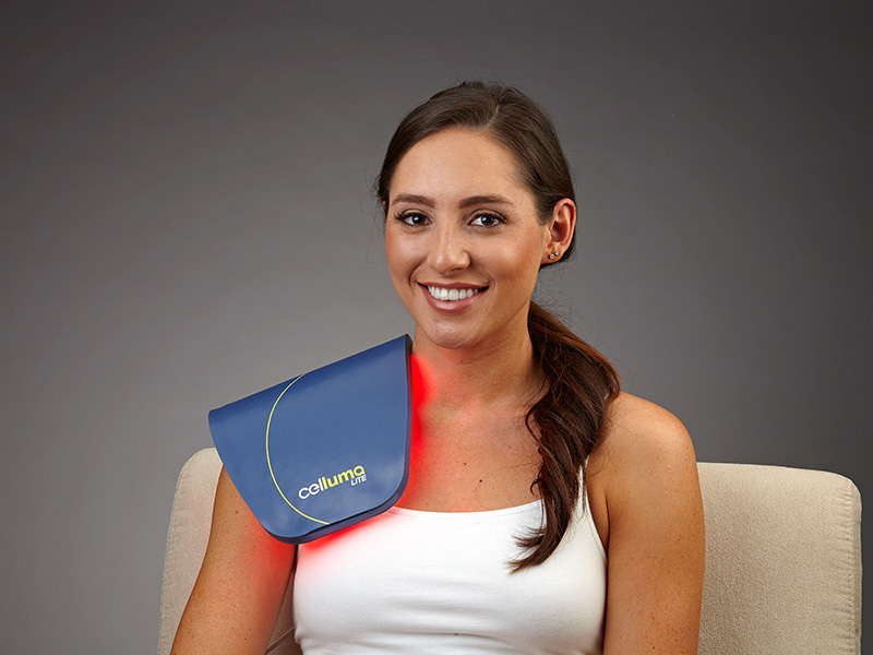 Woman getting infrared red light therapy on right shoulder